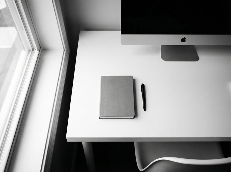 A modern kitchen counter repurposed as a workspace, MacBook next to a pour-over coffee setup (cuqazk5m)