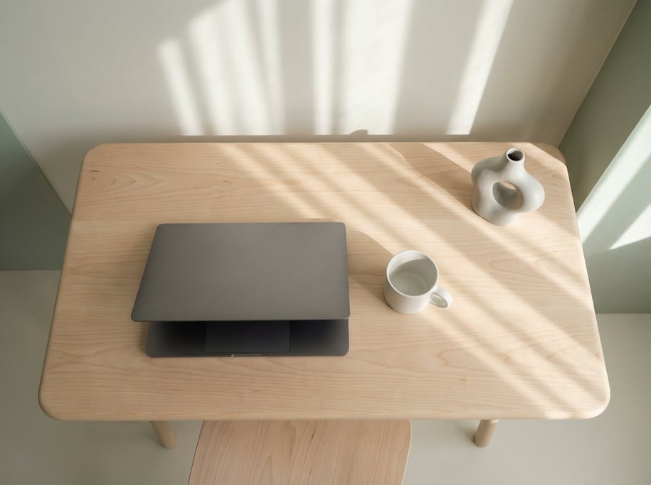 Overhead bird's-eye view looking directly down at a clean smooth sycamore desk with rounded corners
