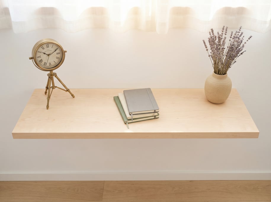 Overhead bird's-eye view looking directly down at a clean floating pale maple shelf desk spanning th