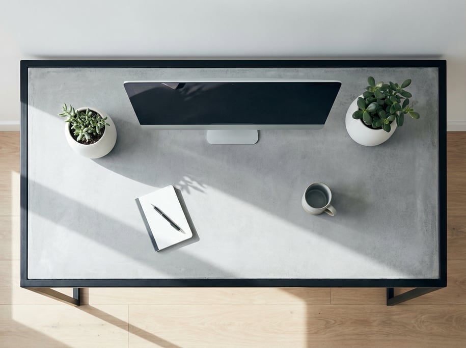 Overhead bird's-eye view looking directly down at a clean minimal concrete-top desk with matte black